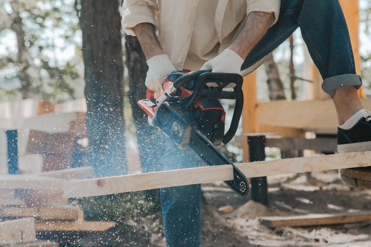 Personne utilisant une tronçonneuse pour couper du bois